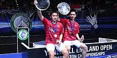 Kevin Sanjaya Sukamuljo and Marcus Fernaldi Gideon pose at the 2017 All England Open podium