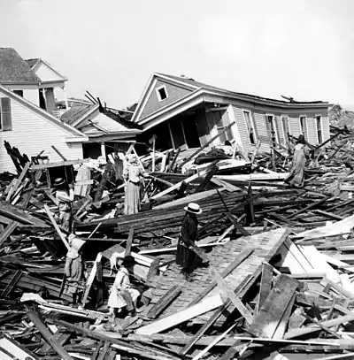 Residents seeking valuables amid piles of wooden debris in the aftermath of the 1900 Galveston hurricane