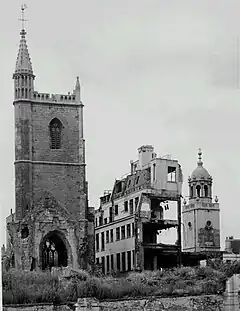 Mary le Port Street, Bristol. A ruined church stands next to the burnt-out remains of a department store.
