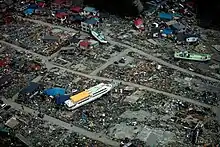 A large ferry boat rests inland amidst destroyed houses after a 9.0 earthquake and subsequent tsunami struck Japan March