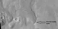 Channel that travels through part of a crater, as seen by HiRISE under HiWish program. The arrow shows a crater that was eroded by the channel.  Note: this is an enlargement of a previous image.