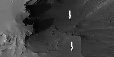 Boulders and their tracks from rolling down a slope, as seen by HiRISE under HiWish program. Arrows show two boulders at the end of their tracks.  Location is Arabia quadrangle.