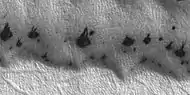 Close view of spring defrosting.  The dark spots are where the ice has disappeared, thus revealing the dark surface beneath the ice.  Picture taken with HiRISE under HiWish program.