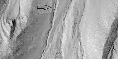 Close view of gully channel, as seen by HiRISE under HiWish program.  Arrow shows small channel within larger channel.  Small channel is quite curved in this image.