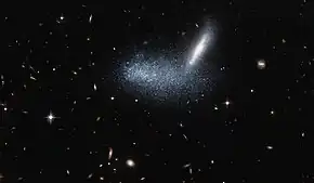 Irregular dwarf galaxy PGC 16389 covers its neighboring galaxy APMBGC 252+125-117.
