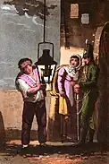 A lamplighter lights the lantern within a lowered light fixture mounted on the side of a building.