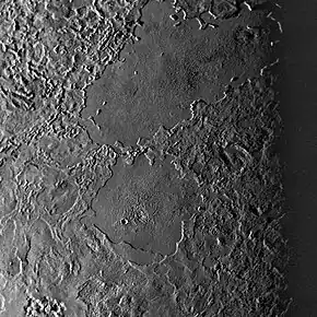 Two large cryolava lakes on Triton, seen west of Leviathan Patera. Combined, they are nearly the size of Kraken Mare on Titan. These features are unusually crater free, indicating they are young and were recently molten.
