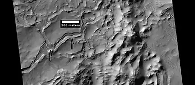 Low, layered mesa, as seen by HiRISE under HiWish program.  Arrows point to some layers.