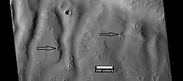 Group of channels on a mound, as seen by HiRISE under HiWish program.  Arrows show eroded craters.