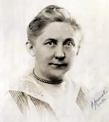 Middle-aged white woman wearing a necklace.