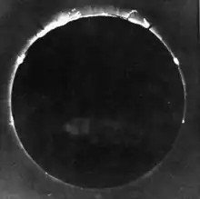 A black-and-white photograph of a total solar eclipse