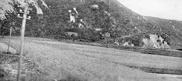 Farmers of forty centuries - Looking across fields of wheat at an eroding hillside.jpg