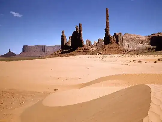 sandy desert area with rocks in the background
